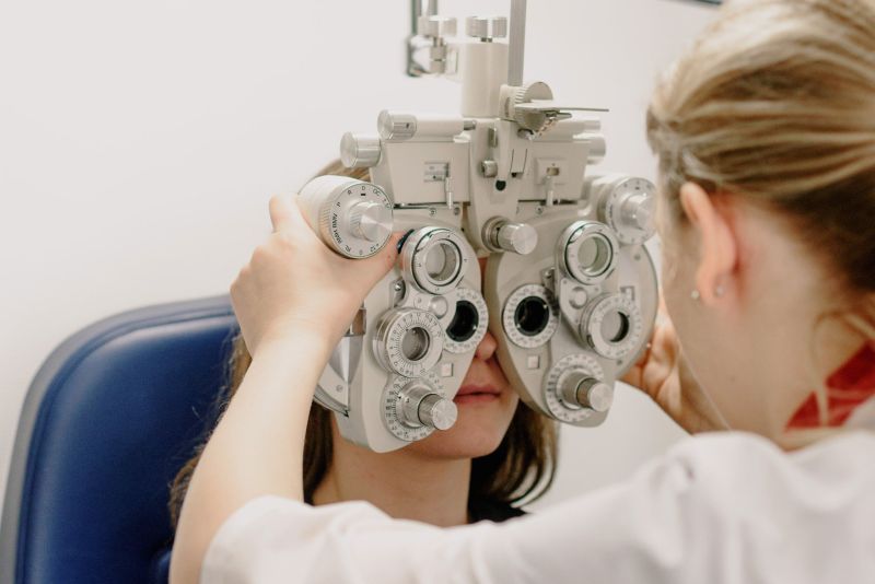 A female optician is testing the eye sight of a man.